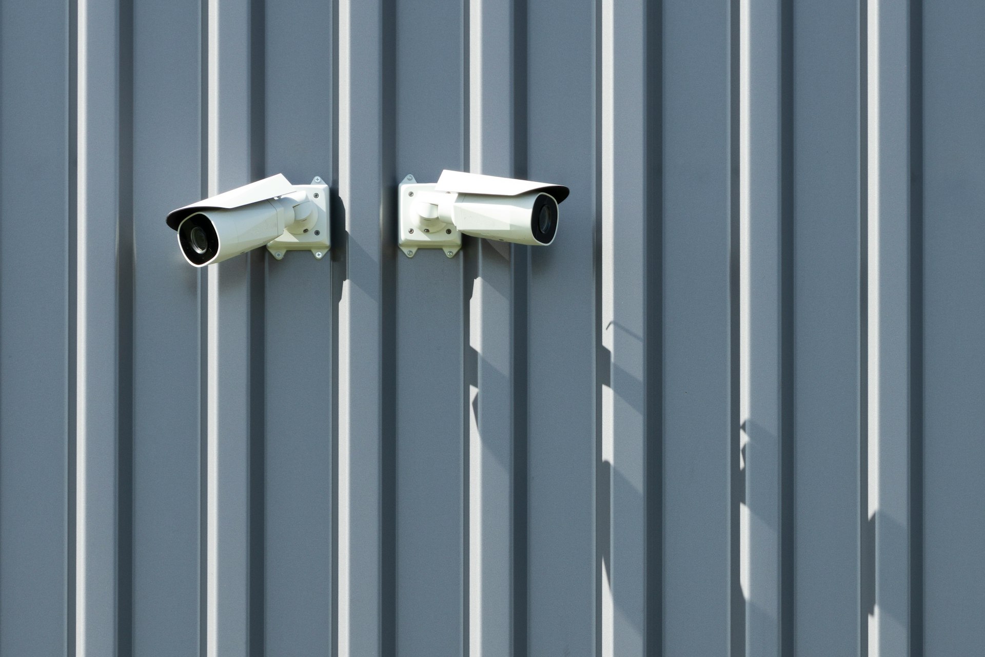 two cameras mounted to the side of a building